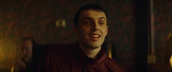 Movie still from “Calm with Horses” (2019), directed by Nick Rowland – A person smiling for the camera; Close Up shot, Low angle