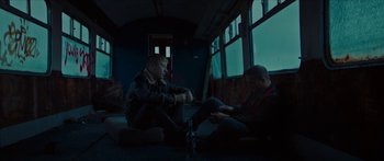 Movie still from “Calm with Horses” (2019), directed by Nick Rowland – Two men sitting on the floor of a train; Wide shot, Low angle