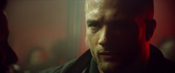 Movie still from “Calm with Horses” (2019), directed by Nick Rowland – A man's face in a dark room; Close Up shot, Low angle