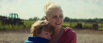 Movie still from “Calm with Horses” (2019), directed by Nick Rowland – A woman and a child smiling for the camera; Close Up shot, Over the shoulder angle