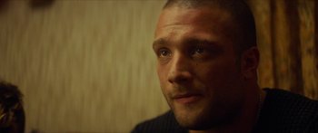 Movie still from “Calm with Horses” (2019), directed by Nick Rowland – A man's face in a black shirt; Close Up shot, Over the shoulder angle