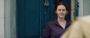 Movie still from “Calm with Horses” (2019), directed by Nick Rowland – A woman standing in front of a blue door; Close Up shot, Over the shoulder angle