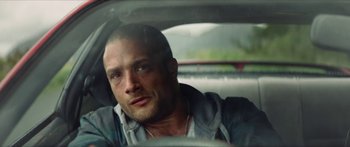 Movie still from “Calm with Horses” (2019), directed by Nick Rowland – A person sitting in a car looking at the camera; Close Up shot, Low angle