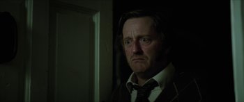 Movie still from “Calm with Horses” (2019), directed by Nick Rowland – A person wearing a suit and tie; Close Up shot, Over the shoulder angle