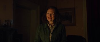 Movie still from “Calm with Horses” (2019), directed by Nick Rowland – A woman in a green jacket smiling for the camera; Close Up shot, Over the shoulder angle