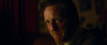 Movie still from “Calm with Horses” (2019), directed by Nick Rowland – A person wearing a suit and tie; Close Up shot, Over the shoulder angle