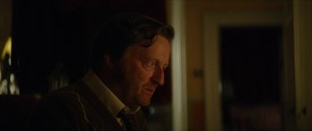 Movie still from “Calm with Horses” (2019), directed by Nick Rowland – A person wearing a suit and tie; Close Up shot, Over the shoulder angle