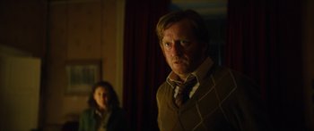 Movie still from “Calm with Horses” (2019), directed by Nick Rowland – A man and a woman standing in a dark room; Medium shot, Over the shoulder angle