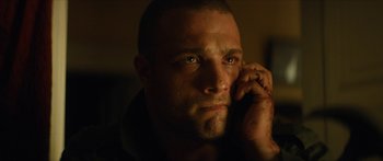 Movie still from “Calm with Horses” (2019), directed by Nick Rowland – A person talking on a cell phone; Close Up shot, Low angle