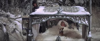 Movie still from “Camelot” (1967), directed by Joshua Logan – A woman and a dog in a carriage in the snow; Wide shot, High angle