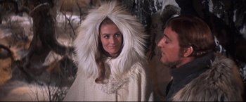 Movie still from “Camelot” (1967), directed by Joshua Logan – A woman in a white fur coat and a man in a white fur coat; Medium shot, Over the shoulder angle