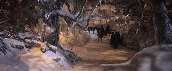 Movie still from “Camelot” (1967), directed by Joshua Logan – A group of people walking down a snow covered path; Wide shot, High angle