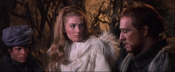 Movie still from “Camelot” (1967), directed by Joshua Logan – A woman in a white fur coat standing next to a man in a white fur coat; Close Up shot, Over the shoulder angle