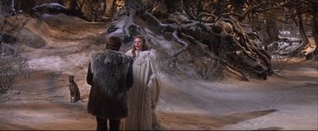 Movie still from “Camelot” (1967), directed by Joshua Logan – A woman in a white dress standing next to a man in fur; Wide shot, High angle