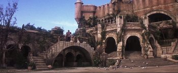 Movie still from “Camelot” (1967), directed by Joshua Logan – Two people standing on a bridge near a castle; Extreme Wide shot, Low angle