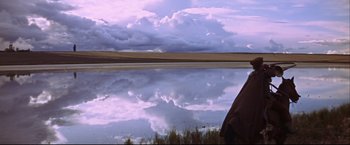 Movie still from “Camelot” (1967), directed by Joshua Logan – A person standing in front of a body of water; Wide shot, Low angle