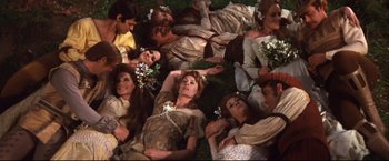 Movie still from “Camelot” (1967), directed by Joshua Logan – A group of people laying on the grass; Wide shot, Overhead angle