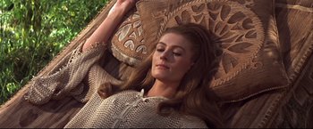 Movie still from “Camelot” (1967), directed by Joshua Logan – A woman laying in a chair with her eyes closed; Close Up shot, High angle