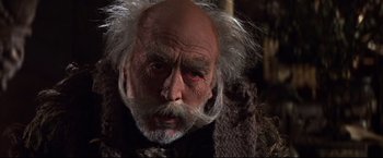 Movie still from “Camelot” (1967), directed by Joshua Logan – An old man with white hair and red eyes; Close Up shot, Low angle
