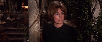 Movie still from “Camelot” (1967), directed by Joshua Logan – A person wearing a black shirt near a tree; Close Up shot, Over the shoulder angle