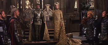 Movie still from “Camelot” (1967), directed by Joshua Logan – A couple of people that are standing up in a room; Wide shot, High angle
