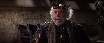 Movie still from “Camelot” (1967), directed by Joshua Logan – An older man with a beard and a crown; Medium shot, Low angle