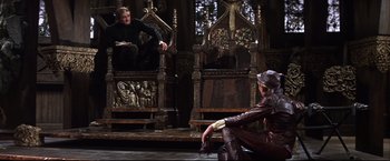 Movie still from “Camelot” (1967), directed by Joshua Logan – A man and a woman sitting on a wooden bench; Wide shot, Over the shoulder angle