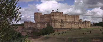 Movie still from “Camelot” (1967), directed by Joshua Logan – A group of cows standing on top of a grass covered field; Extreme Wide shot, Low angle