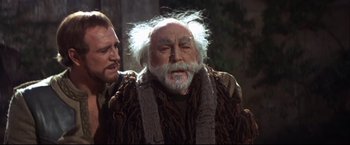 Movie still from “Camelot” (1967), directed by Joshua Logan – An old man with a beard and a mustache; Medium shot, Over the shoulder angle