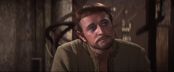 Movie still from “Camelot” (1967), directed by Joshua Logan – A person with a beard and mustache; Close Up shot, Over the shoulder angle