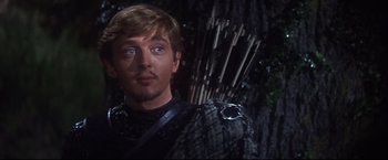 Movie still from “Camelot” (1967), directed by Joshua Logan – A person holding a bow and arrow; Close Up shot, Over the shoulder angle