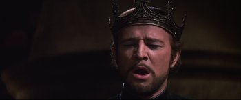 Movie still from “Camelot” (1967), directed by Joshua Logan – A person wearing a crown with his mouth open; Close Up shot, Low angle