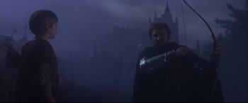 Movie still from “Camelot” (1967), directed by Joshua Logan – A man standing in front of a castle in the dark; Medium shot, Low angle