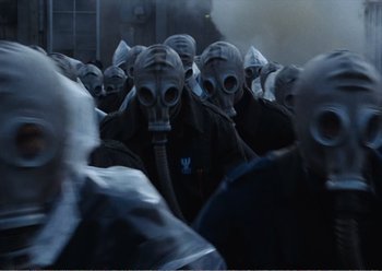 Movie still from “Camera Buff” (1979), directed by Krzysztof Kieslowski – A group of people wearing gas masks in the dark; Close Up shot, High angle