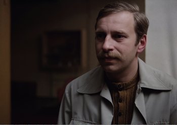 Movie still from “Camera Buff” (1979), directed by Krzysztof Kieslowski – A person wearing a jacket; Close Up shot, Over the shoulder angle