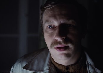 Movie still from “Camera Buff” (1979), directed by Krzysztof Kieslowski – A person wearing a jacket; Close Up shot, Low angle