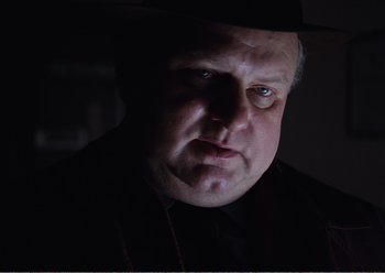 Movie still from “Camera Buff” (1979), directed by Krzysztof Kieslowski – A person wearing a black shirt; Close Up shot, Low angle