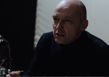 Movie still from “Camera Buff” (1979), directed by Krzysztof Kieslowski – A man with bald head sitting at a table; Close Up shot, Over the shoulder angle