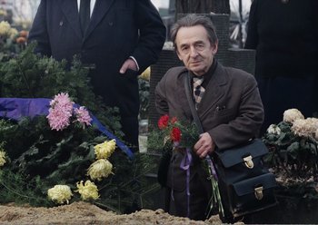 Movie still from “Camera Buff” (1979), directed by Krzysztof Kieslowski – An older man in a brown suit holding a black briefcase; Medium shot, High angle