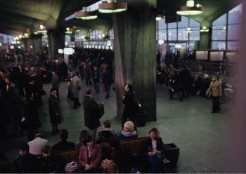 Movie still from “Camera Buff” (1979), directed by Krzysztof Kieslowski – A group of people sitting on a bench in a building; Extreme Wide shot, High angle