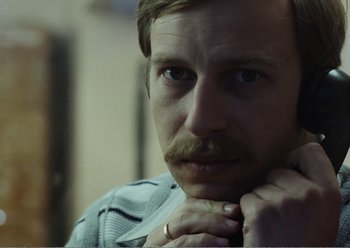 Movie still from “Camera Buff” (1979), directed by Krzysztof Kieslowski – A person with a mustache; Close Up shot, Over the shoulder angle