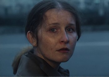Movie still from “Camera Buff” (1979), directed by Krzysztof Kieslowski – A person wearing a brown jacket; Close Up shot, Over the shoulder angle