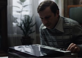 Movie still from “Camera Buff” (1979), directed by Krzysztof Kieslowski – A man is looking at a computer keyboard; Medium shot, Low angle