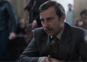 Movie still from “Camera Buff” (1979), directed by Krzysztof Kieslowski – A man in a gray suit and a brown tie; Close Up shot, Over the shoulder angle