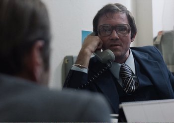 Movie still from “Camera Buff” (1979), directed by Krzysztof Kieslowski – A man in a suit talking on the phone; Medium shot, Over the shoulder angle