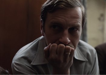 Movie still from “Camera Buff” (1979), directed by Krzysztof Kieslowski – A person with his hand to his face; Close Up shot, Low angle