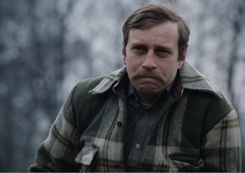 Movie still from “Camera Buff” (1979), directed by Krzysztof Kieslowski – A person wearing a jacket; Close Up shot, Over the shoulder angle