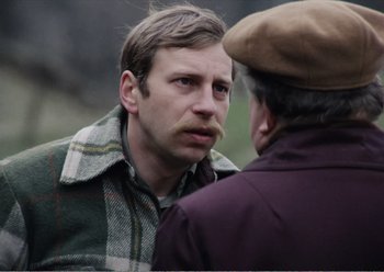 Movie still from “Camera Buff” (1979), directed by Krzysztof Kieslowski – A man with a mustache talking to another man; Close Up shot, Over the shoulder angle