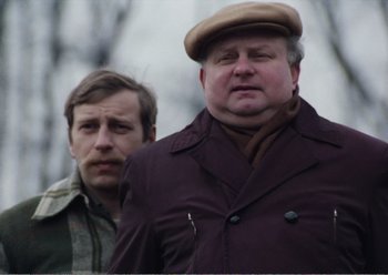 Movie still from “Camera Buff” (1979), directed by Krzysztof Kieslowski – Two men standing next to each other in a forest; Close Up shot, Low angle