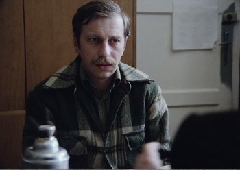 Movie still from “Camera Buff” (1979), directed by Krzysztof Kieslowski – A man sitting in front of a mirror in a room; Close Up shot, Over the shoulder angle